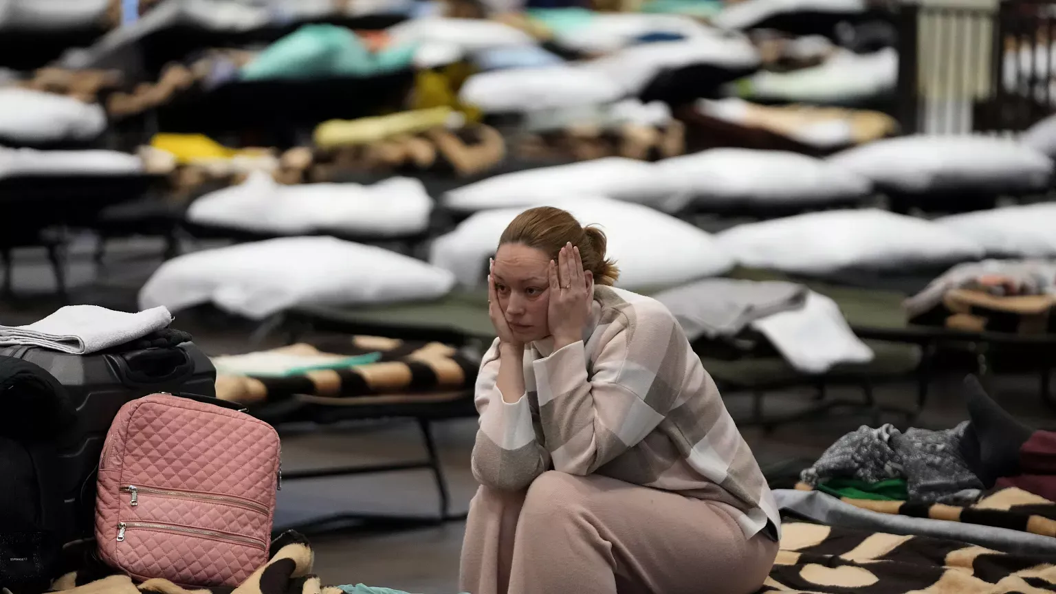 A stressed woman sitting with her head in her hands