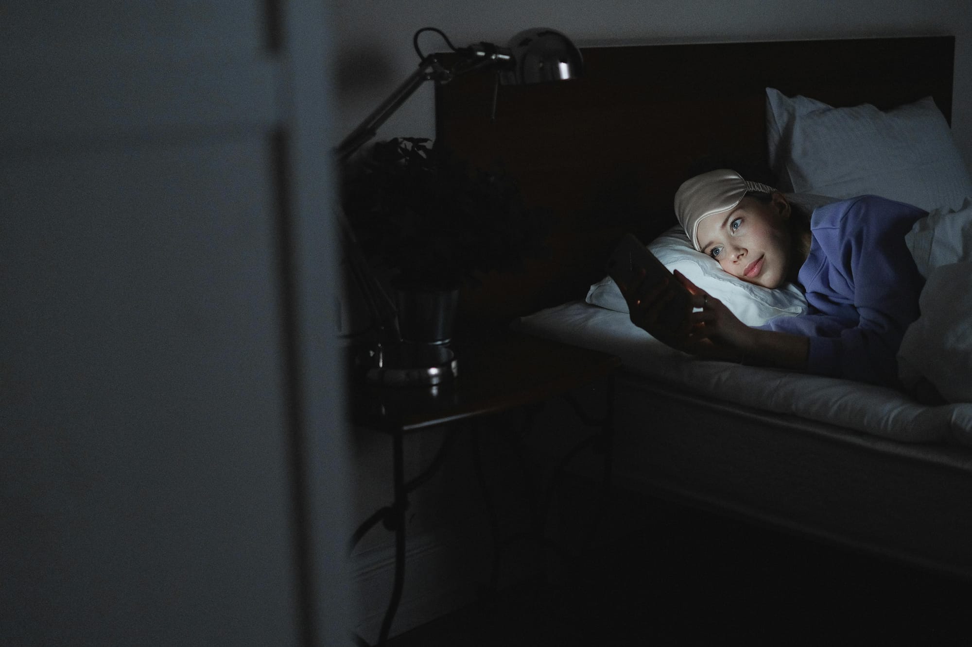 Girl laying in her bed looking at her phone