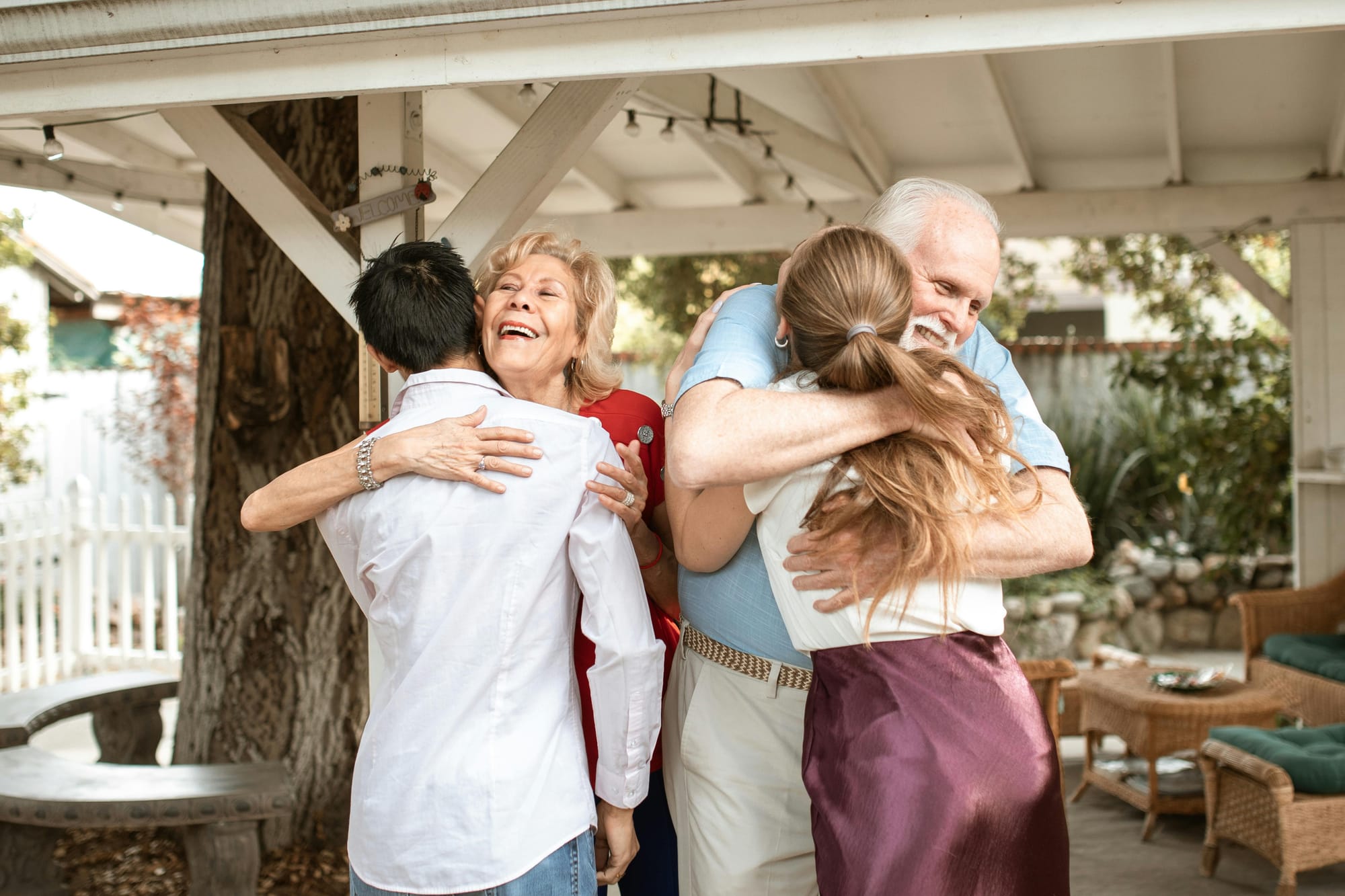 Holiday season family gathering where grandparents and grandchildren hug warmly outdoors.