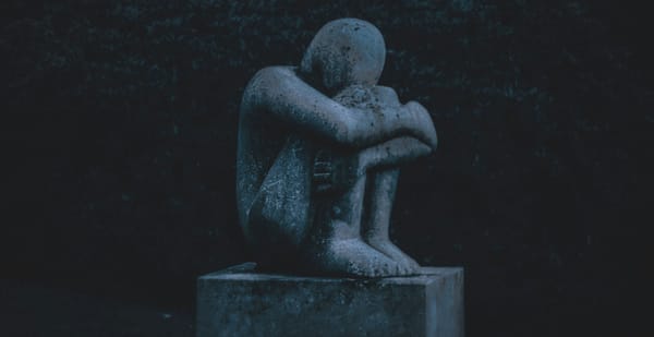 A statue of a depressed man